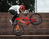 Gabriel Wibmer balanciert auf seinem roten Canyon Bike auf einer Treppe.