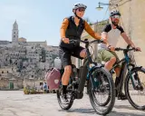 Ein Paar genießt eine Fahrt mit ihrem Buddy Bike durch eine historische Stadt.