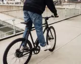 Ein Mann fährt ein schwarzes Fahrrad. Die Marke "sushi" ist auf dem Rahmen zu sehen. Die Nachricht "vanmoof insolvent" hallt nach.