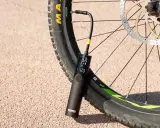 Eine tragbare Pumpe mit digitaler Anzeige ist an einem Fahrradreifen befestigt, der ein Presta Ventil hat.