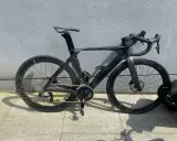 Schwarzes Rennrad mit aerodynamischem carbon rahmen und tiefen Felgen, bereit für die nächste Fahrt.