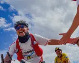 Glücklicher Radfahrer gibt High-Five während Paris Brest Paris. Ein weiterer Radfahrer im Hintergrund.