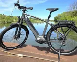 Graues E-Bike am Wasser. Die Preisentwicklung von E-Bikes ist spannend, dieses Modell bietet Komfort und Leistung.