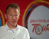 Fabian Wegmann spricht vor dem Logo der Deutschland Tour. Seine Vergangenheit mit Doping-Vorwürfen wirft einen Schatten auf seine Karriere.
