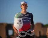 Felix Gall feiert seinen Sieg mit einem Pokal in Weinglasform und einer Infinity-Trophäe.