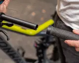 Person wechselt Fahrradgriffe. Der Lenker ist freigelegt, die neue Griff wird bereitgehalten.