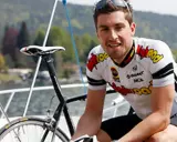 Bernie Eisel, Radsportler, lächelt neben seinem Rennrad auf einem Boot.