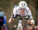 Fem van Empel zeigt Zunge beim Radrennen, trägt weißes Trikot mit Jumbo Visma Logo.