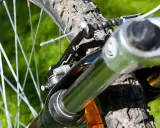 Nahaufnahme einer Fahrradfedergabel mit Stahlfeder. Die Federgabel ist auf das Gelände eingestellt.