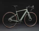 Grünes Cannondale Topstone Neo SL 2 Gravelbike mit braunen Reifen. Das geringe cannondale topstone neo sl 2 gewicht macht es agil.