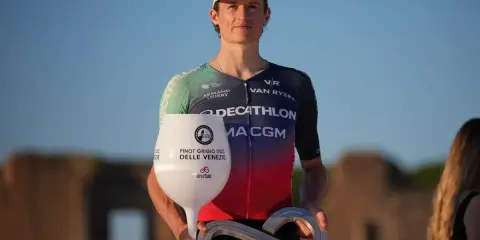 Felix Gall feiert seinen Sieg mit einem Pokal in Weinglasform und einer Infinity-Trophäe.