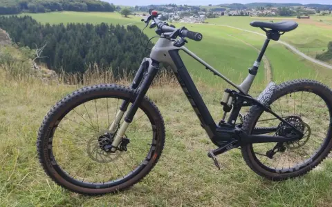 Ein E-Bike steht auf einem Hügel mit Blick auf grüne Felder und Wälder. Perfekt für eine Tour mit dem e-bike auf den Brocken.