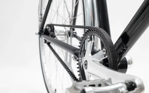 Nahaufnahme des Fahrradrahmens mit einem glänzenden Carbon Drive Riemenantrieb, der über Zahnräder läuft.