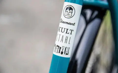 Ein **Diamant**-Fahrrad mit dem Schriftzug "KULT STAHL" und einem lustigen Comic-Gesicht.