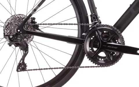 Nahaufnahme des Hinterrads und der Kurbelgarnitur eines schwarzen Fahrrads mit der besten Shimano Schaltung.