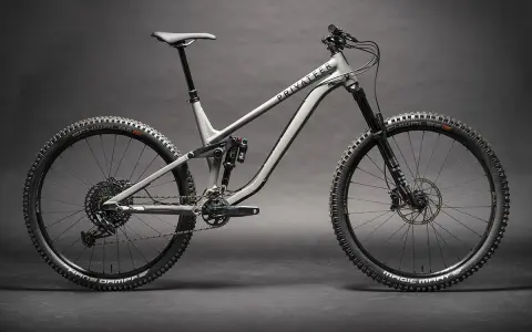 Ein graues Fullsuspension-Mountainbike der Marke Privateer steht auf dunklem Grund. Dieses Bike ist bereit für jedes Abenteuer.