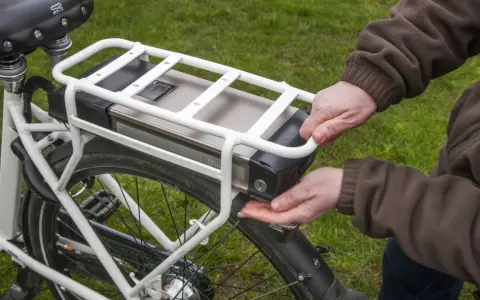 Hände lösen den Akku eines E-Bikes. Korrektes e bike akku entsorgen ist wichtig für die Umwelt.