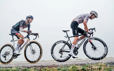 Pavel Sivakov kämpft sich auf seinem Rad einen nebligen Anstieg hinauf, während ein Konkurrent im UAE-Trikot neben ihm fährt.