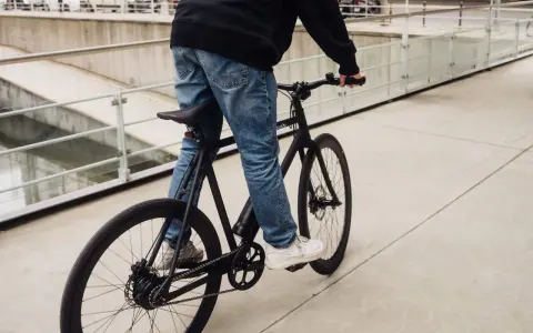 Ein Mann fährt ein schwarzes Fahrrad. Die Marke "sushi" ist auf dem Rahmen zu sehen. Die Nachricht "vanmoof insolvent" hallt nach.