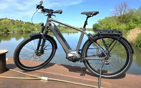 Graues E-Bike am Wasser. Die Preisentwicklung von E-Bikes ist spannend, dieses Modell bietet Komfort und Leistung.