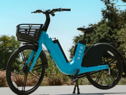 Ein blaues Bird E-Bike mit Korb steht im Freien. Gute Bird Bike Erfahrungen sind garantiert, wenn man die Stadt so erkundet.
