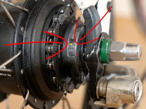 Rote Pfeile zeigen auf die Markierungen zum shimano nexus 8 einstellen. Nahaufnahme einer Nabenschaltung.