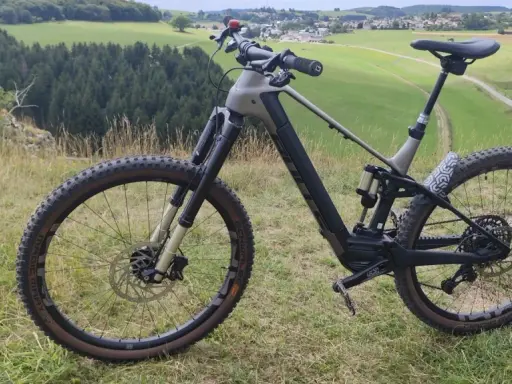 Ein E-Bike steht auf einem Hügel mit Blick auf grüne Felder und Wälder. Perfekt für eine Tour mit dem e-bike auf den Brocken.