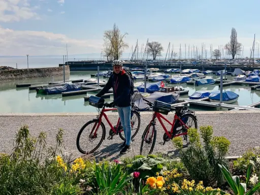 Mann mit Rennrad am Bodensee, bereit für die Bodensee Umrundung. Boote im Hafen.