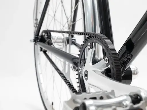 Nahaufnahme des Fahrradrahmens mit einem glänzenden Carbon Drive Riemenantrieb, der über Zahnräder läuft.