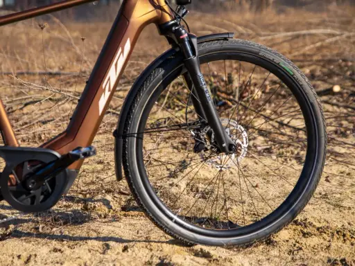 Vorderreifen und Federgabel eines braunen KTM Macina Style E-Bikes. Der Unterschied zwischen dem KTM Macina Style 720 und 730 liegt in den Details.