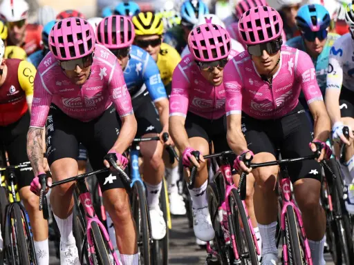 Radfahrer im pinken Trikot mit "Education First Team" Aufdruck, konzentriert auf der Strecke.