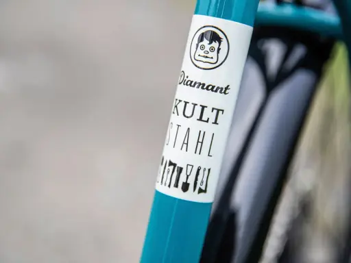 Ein **Diamant**-Fahrrad mit dem Schriftzug "KULT STAHL" und einem lustigen Comic-Gesicht.