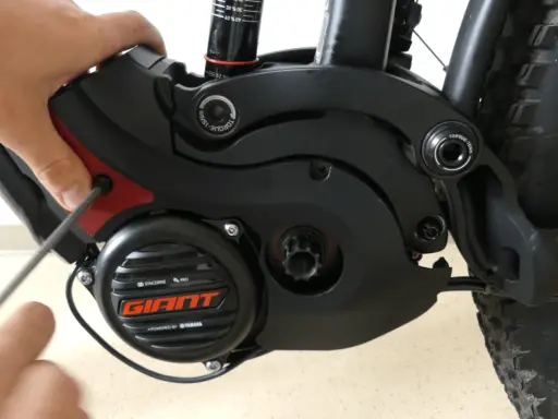 Hand schraubt am Giant SyncDrive Sport Motor. Mögliche Probleme mit dem E-Bike Antrieb.