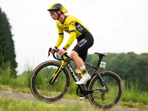 Matthew Brennan im gelben Trikot fährt auf seinem Rennrad durch eine grüne Landschaft.
