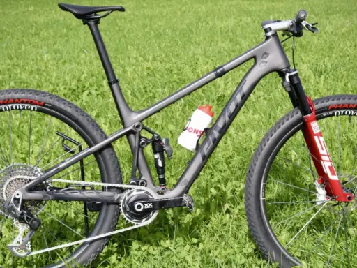 Ein graues Mountainbike mit roten Akzenten auf der Gabel und einer Trinkflasche. Die Reifen tragen die Aufschrift "Phantom Proven". Ein tolles Rad für die letzten Bikes der Saison.