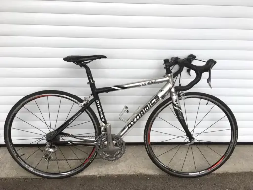 Silbernes Rennrad DYNAMICS RSL COMP mit schwarzen Akzenten, bereit für die nächste Fahrt.