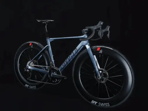 Ein elegantes, hellblaues Rennrad, das myvelo Verona, steht vor schwarzem Hintergrund. Seine aerodynamischen Felgen und die schlanke Silhouette versprechen Geschwindigkeit.