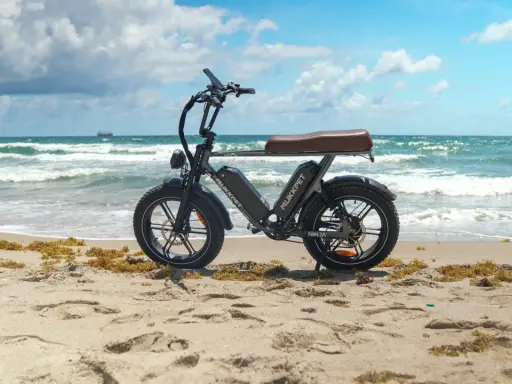 Schwarzes E-Bike am Strand. Die Frage "wieviel Watt sollte ein E-Bike haben?" beschäftigt viele. Dieses Modell ist bereit für Abenteuer.