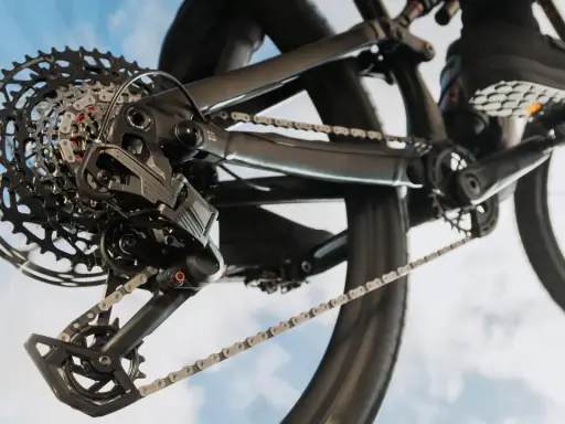 Nahaufnahme einer SRAM Schaltung am Fahrrad. Die Kette läuft über die Kassette, während ein Schuh auf dem Pedal zu sehen ist. Perfekt, um die SRAM Schaltung einzustellen.