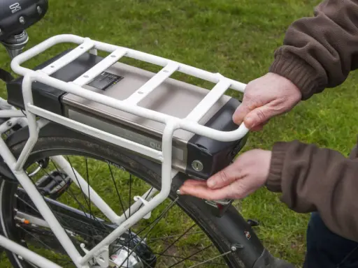 Hände lösen den Akku eines E-Bikes. Korrektes e bike akku entsorgen ist wichtig für die Umwelt.