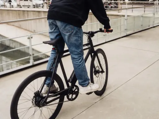 Ein Mann fährt ein schwarzes Fahrrad. Die Marke "sushi" ist auf dem Rahmen zu sehen. Die Nachricht "vanmoof insolvent" hallt nach.