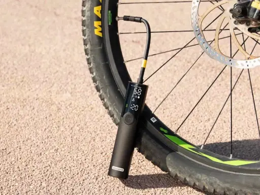 Eine tragbare Pumpe mit digitaler Anzeige ist an einem Fahrradreifen befestigt, der ein Presta Ventil hat.