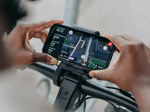 Hände halten Smartphone mit Bosch Flow App Navigation offline. Karte zeigt Route, Distanz und Geschwindigkeit.