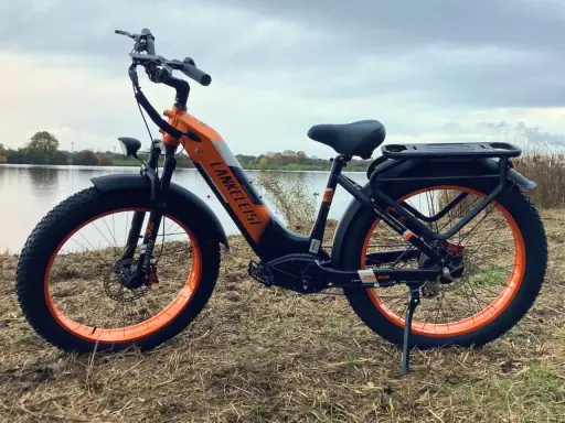 Orange-schwarzes E-Bike mit breiten Reifen am Seeufer. Gute Lankeleisi Erfahrungen sind garantiert mit diesem robusten Fatbike.