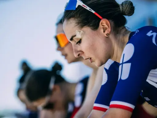 Juliette Labous, mit Pflaster auf der Stirn, konzentriert sich vor dem Rennen. Ihre Teamkolleginnen sind im Hintergrund zu sehen.