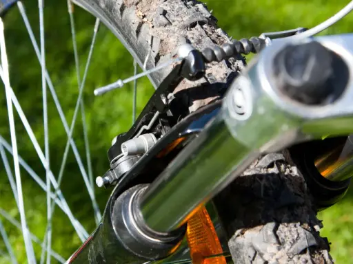 Nahaufnahme einer Fahrradfedergabel mit Stahlfeder. Die Federgabel ist auf das Gelände eingestellt.
