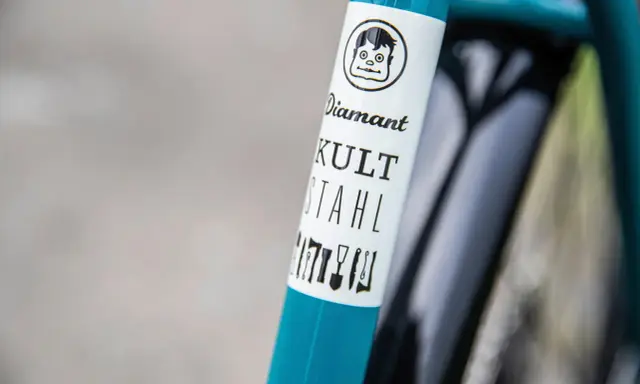 Ein **Diamant**-Fahrrad mit dem Schriftzug "KULT STAHL" und einem lustigen Comic-Gesicht.