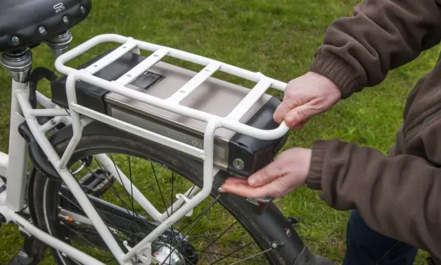 Hände lösen den Akku eines E-Bikes. Korrektes e bike akku entsorgen ist wichtig für die Umwelt.