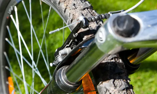 Nahaufnahme einer Fahrradfedergabel mit Stahlfeder. Die Federgabel ist auf das Gelände eingestellt.