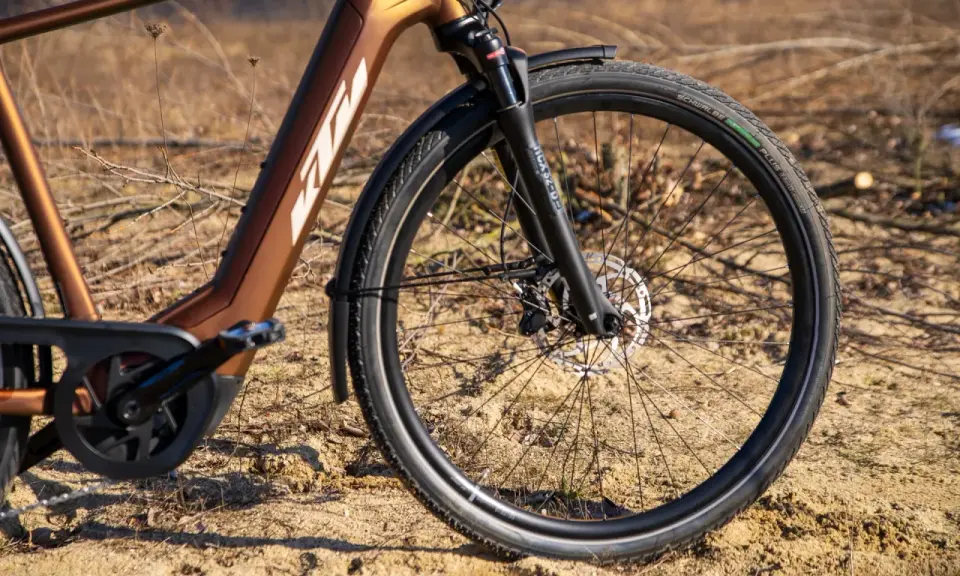 Vorderreifen und Federgabel eines braunen KTM Macina Style E-Bikes. Der Unterschied zwischen dem KTM Macina Style 720 und 730 liegt in den Details.